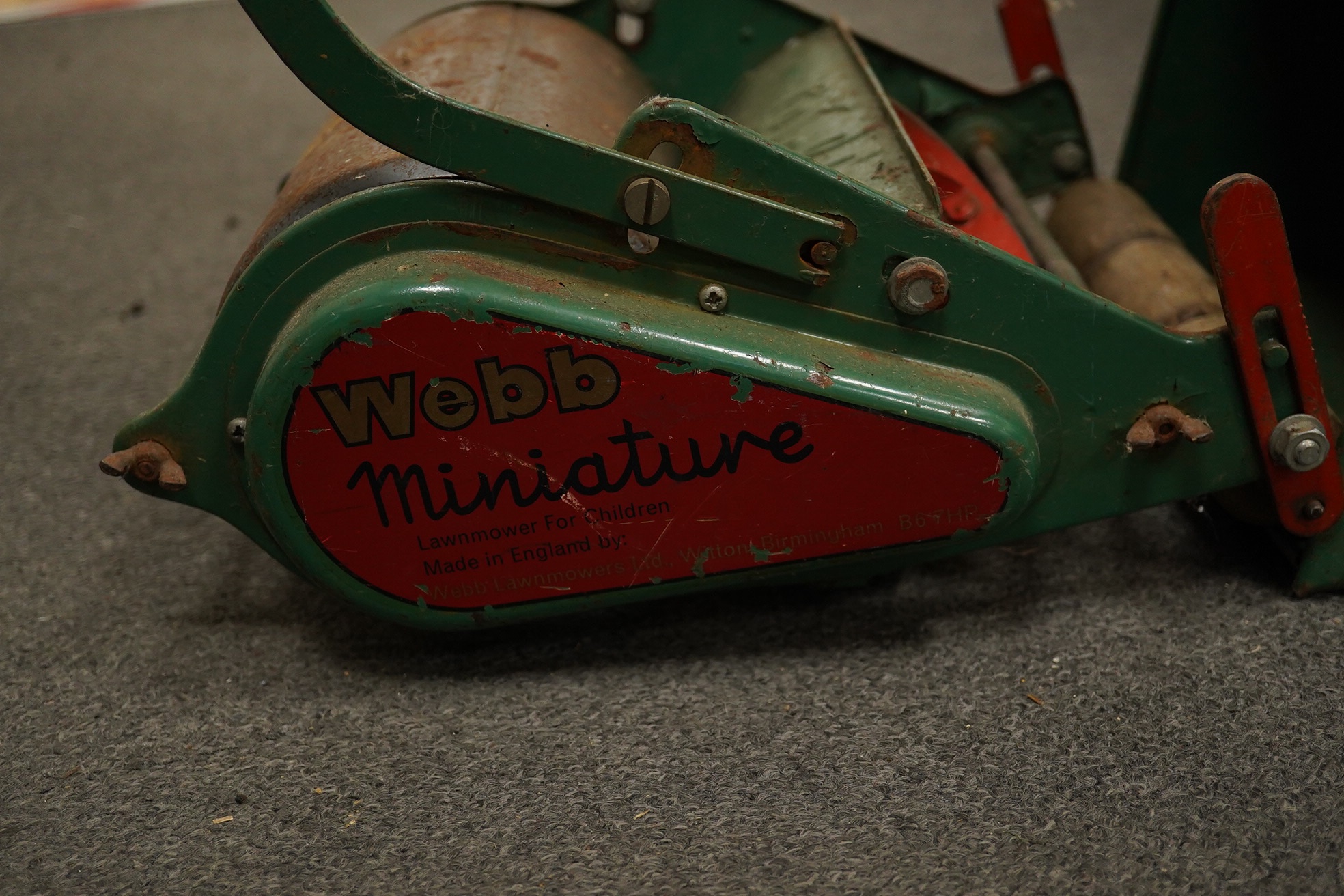 A late 1950s child's Webb push along scale model lawn mower, with Webb transfers to the grass box and side of the body and rubber handles, 63cm high. Condition - fair, some surface rust and general age related damage and